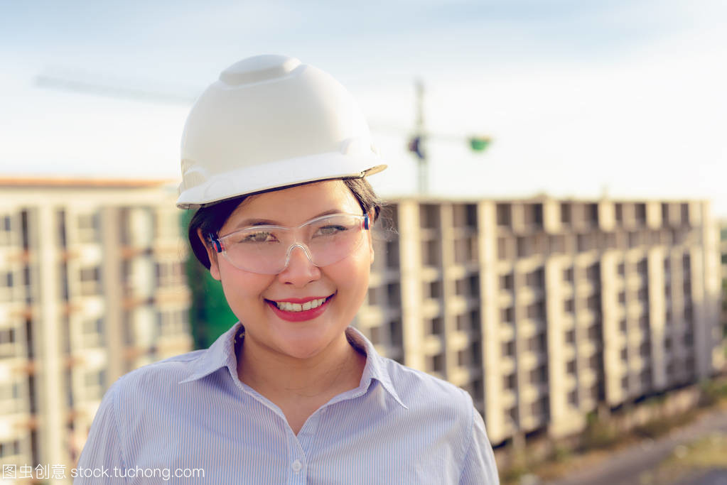 日落背景后建筑工地前土建工程女人员的特写画像